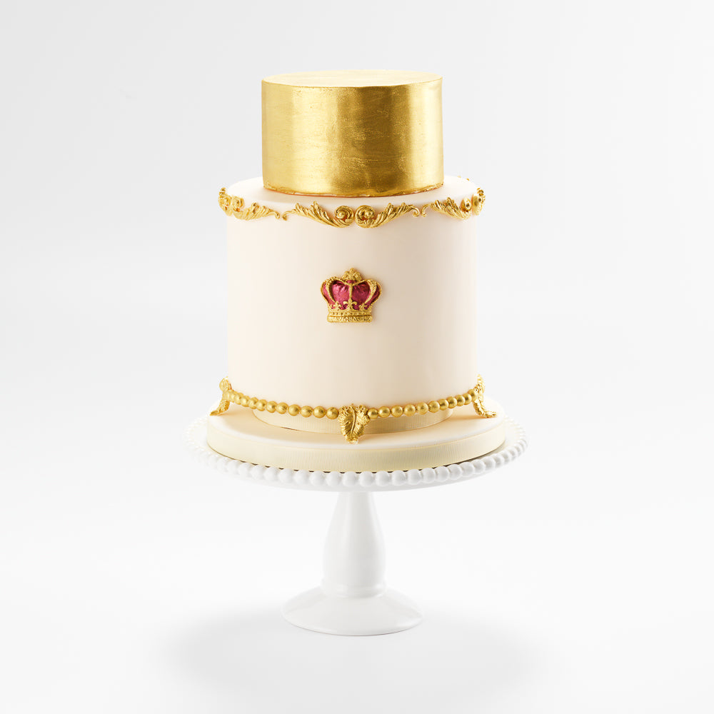 This beautiful two tier celebration cake decorated with ornate gold moulding, and a regal crown serves 40 portions