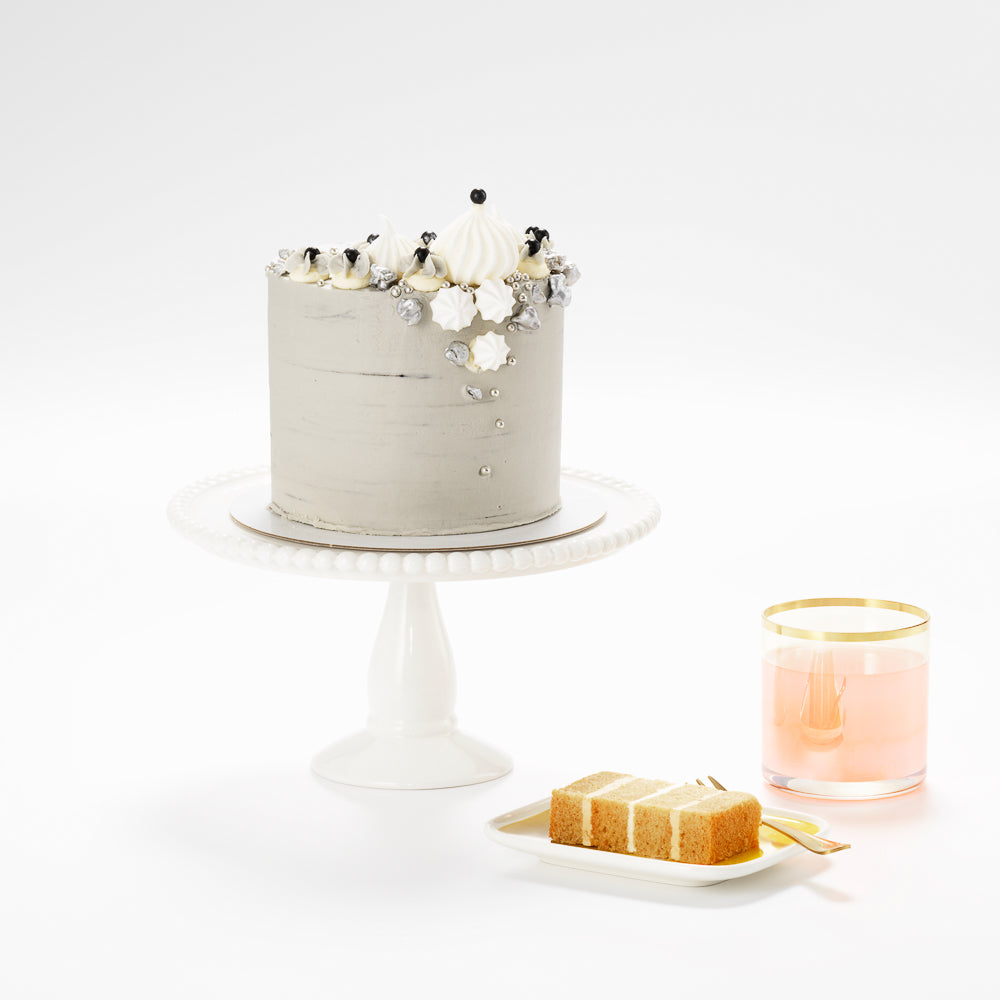 A  grey marbled buttercream salted caramel cake which is topped with tumbling meringue clouds and silver popcorn 