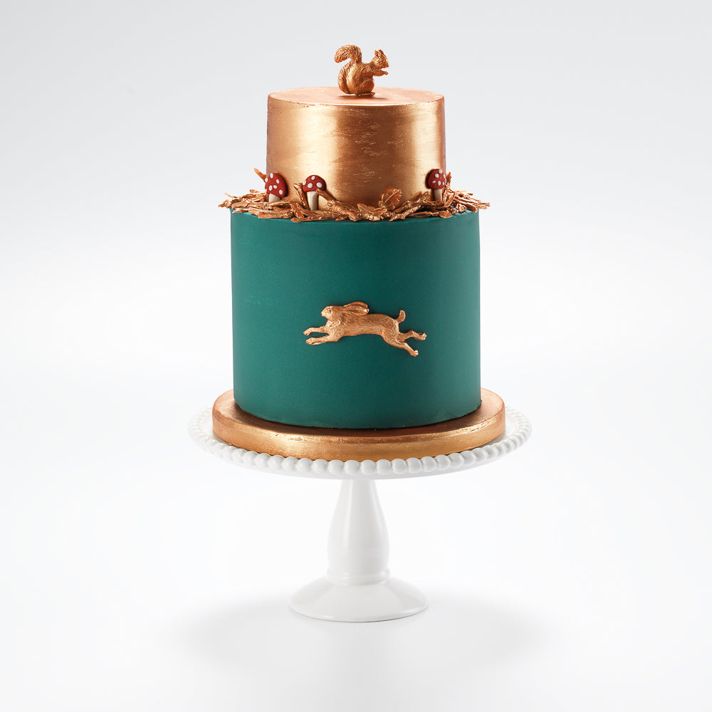 An autumnal forest cake, ideal for a mans birthday cake. It has a metallic copper top tier, with details of a copper sugar squirrel and hare nestling amongst autumn sugar leaves